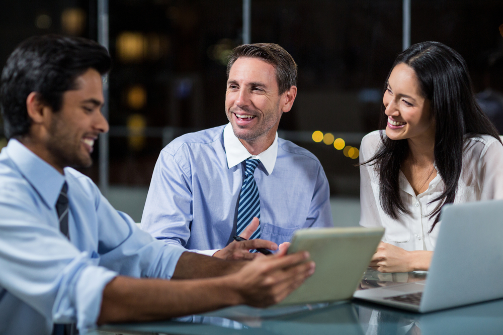 Businessman discussing with colleagues over digital tablet in the office